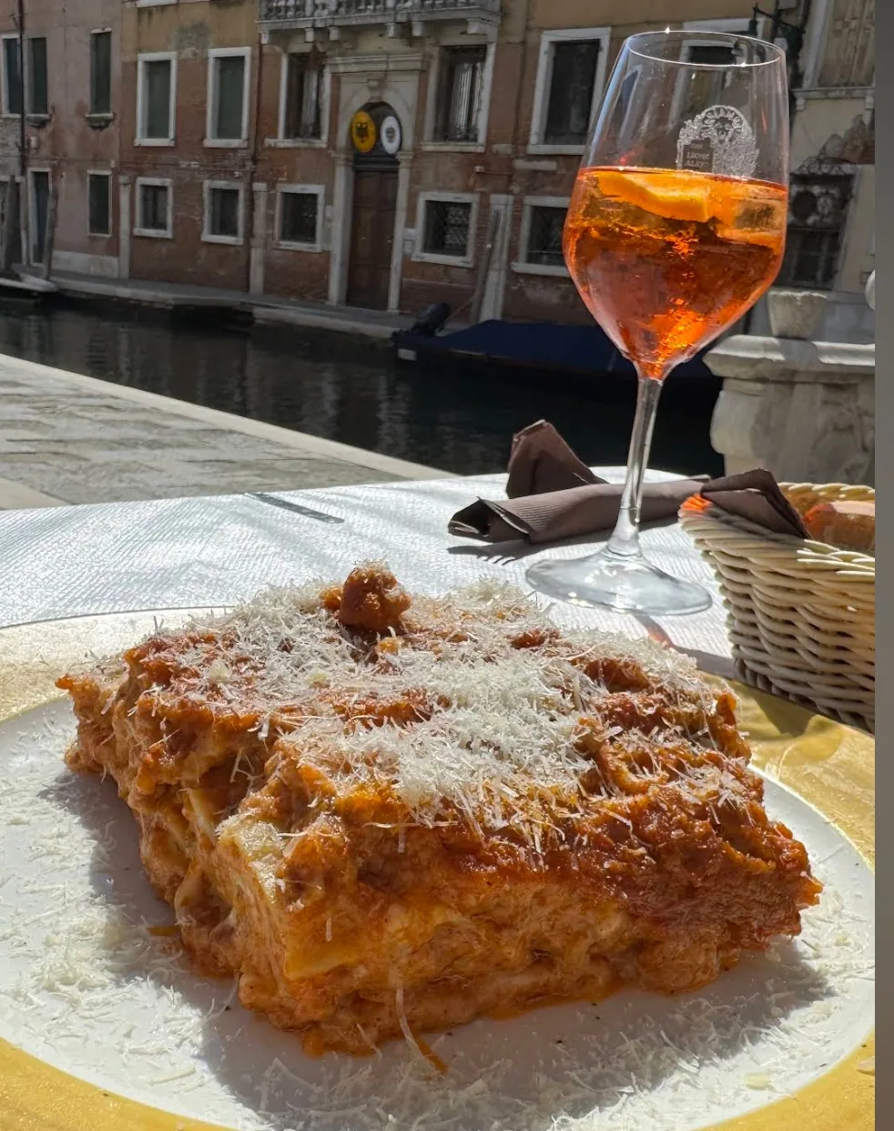 Lasagne with parmigiano and a spritz, terrace overlooking the canal