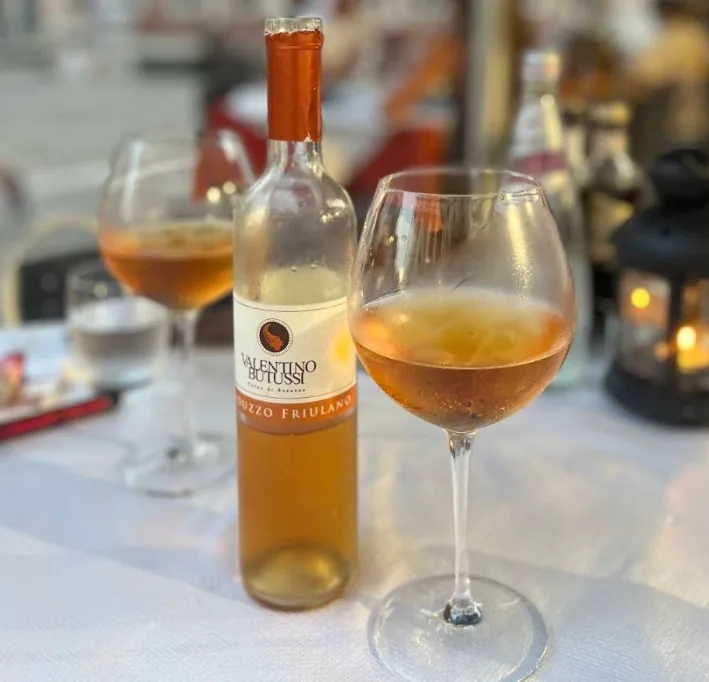 Bottle of Valentino Butussi Friulano with a glass on a candle-lit table